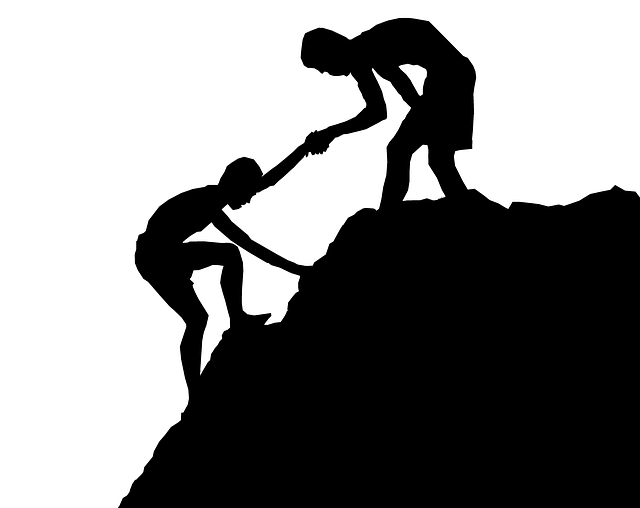 a person helping another up a hill